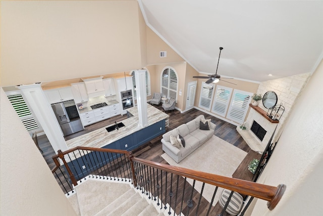 2260 Teas Crossing Dr, Conroe, TX 77304 - living room featuring a large fireplace, high vaulted ceiling, a ceiling fan, dark wood-style floors, and baseboards