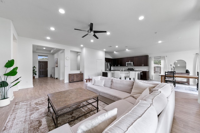 25219 Easton Ramsey Way, Richmond, TX 77406 - living room with arched walkways, a ceiling fan, recessed lighting, light wood-style flooring, and baseboards