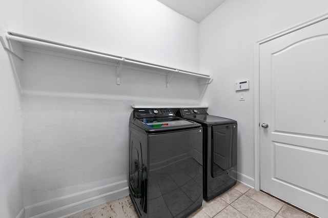 25219 Easton Ramsey Way, Richmond, TX 77406 - laundry area featuring washing machine and clothes dryer, light tile patterned floors, and baseboards