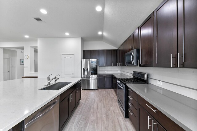 25219 Easton Ramsey Way, Richmond, TX 77406 - kitchen with stainless steel appliances, a sink, light wood-style floors, recessed lighting, and lofted ceiling
