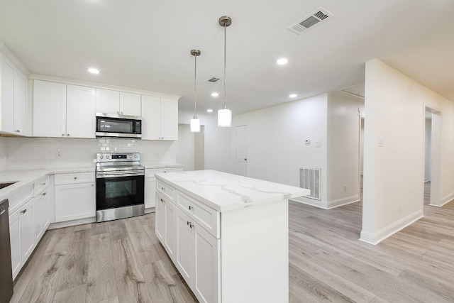 527 Fm 787th Rd E, Cleveland, TX 77327 - kitchen with appliances with stainless steel finishes, a center island, backsplash, light wood-style flooring, and recessed lighting
