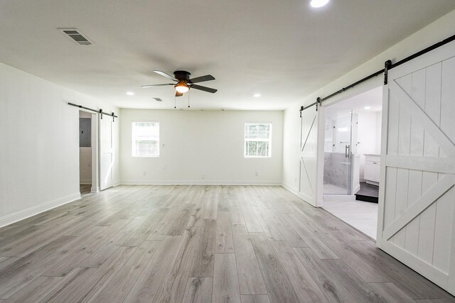527 Fm 787th Rd E, Cleveland, TX 77327 - spare room with a barn door, a ceiling fan, light wood-style flooring, recessed lighting, and baseboards