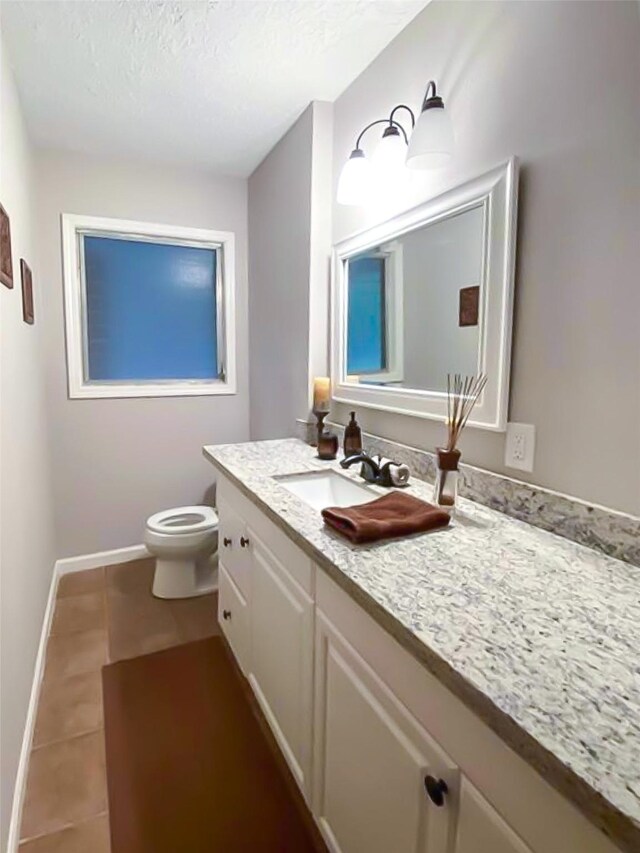 717 Grantham Rd, Baytown, TX 77521 - bathroom with tile patterned flooring, vanity, toilet, baseboards, and a textured ceiling