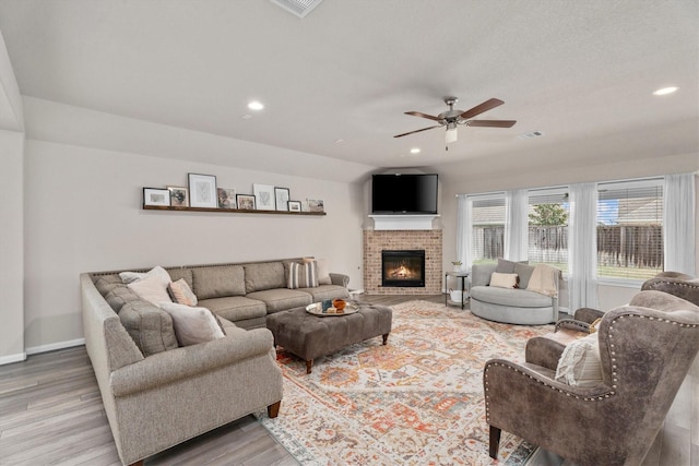 2221 Hay Field Ct, Conroe, TX 77384 - living room featuring light wood-style floors, ceiling fan, recessed lighting, baseboards, and a fireplace