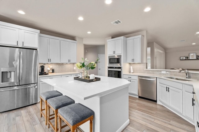 2221 Hay Field Ct, Conroe, TX 77384 - kitchen with stainless steel appliances, a sink, backsplash, recessed lighting, and a kitchen bar