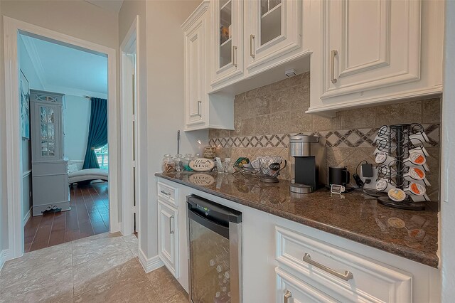8807 Stones Throw Ln, Missouri City, TX 77459 - kitchen featuring white cabinetry, dark stone counters, glass insert cabinets, and backsplash