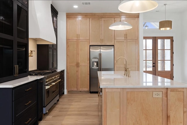 16685 Kelton, Iola, TX 77861 - kitchen with light brown cabinetry, stainless steel appliances, a sink, light countertops, and light wood-style flooring