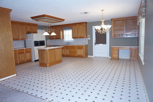 19710 Lowe St, Porter, TX 77365 - kitchen with a chandelier, a center island, baseboards, light countertops, and a sink