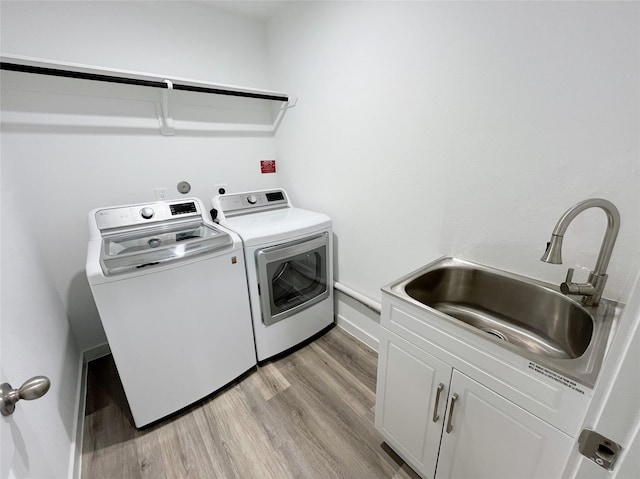 3231 Langley Bend Ln, Fulshear, TX 77441 - laundry room featuring washing machine and clothes dryer, cabinet space, and light wood-style floors