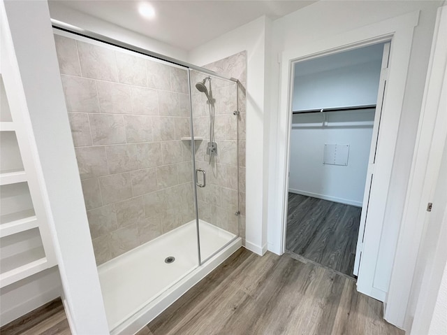 3231 Langley Bend Ln, Fulshear, TX 77441 - bathroom featuring a stall shower, a spacious closet, wood finished floors, and baseboards
