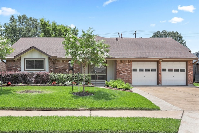 1109 Alan St, Deer Park, TX 77536 - view of front of property featuring a garage, driveway, brick siding, a front yard, and a shingled roof