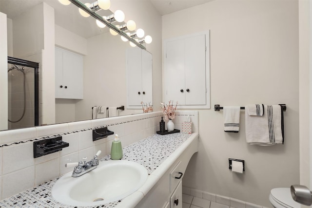 1109 Alan St, Deer Park, TX 77536 - bathroom featuring decorative backsplash, vanity, toilet, tile patterned floors, and a tile shower