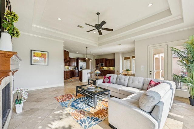 24807 Thorton Knolls Dr, Spring, TX 77389 - living room with a raised ceiling, recessed lighting, ceiling fan, a fireplace, and crown molding