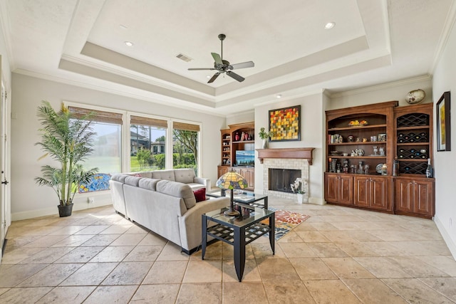 24807 Thorton Knolls Dr, Spring, TX 77389 - living area with a tray ceiling, a ceiling fan, a fireplace, ornamental molding, and baseboards