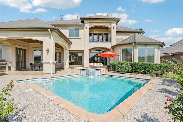 24807 Thorton Knolls Dr, Spring, TX 77389 - back of house featuring a balcony, an outdoor kitchen, french doors, a patio area, and a pool with connected hot tub