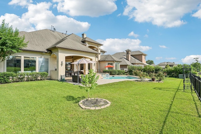 24807 Thorton Knolls Dr, Spring, TX 77389 - rear view of property featuring a pool with connected hot tub, a patio, stucco siding, and roof with shingles