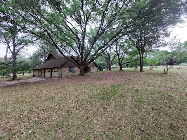 206 Garden W, Conroe, TX 77304 - view of grassy yard featuring an attached garage and concrete driveway