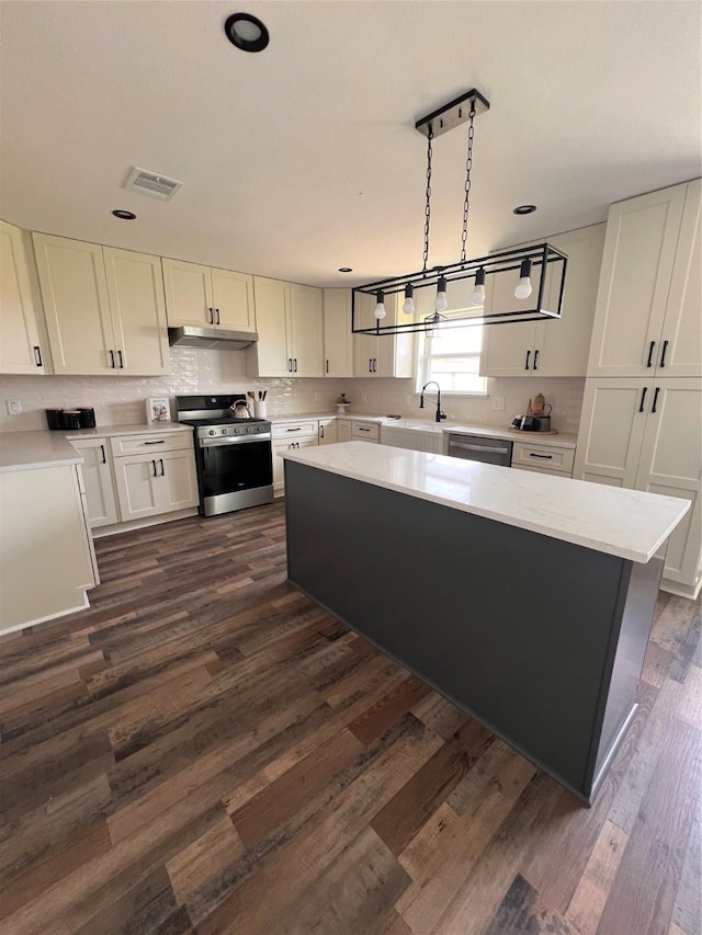 1618 Del Norte St, Houston, TX 77018 - kitchen with stainless steel appliances, under cabinet range hood, a sink, light countertops, and backsplash