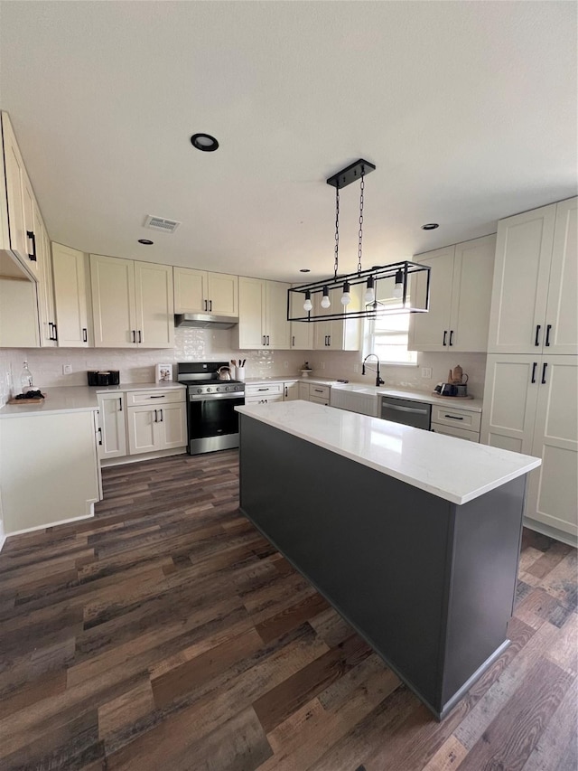 1618 Del Norte St, Houston, TX 77018 - kitchen with stainless steel appliances, a sink, under cabinet range hood, light countertops, and tasteful backsplash