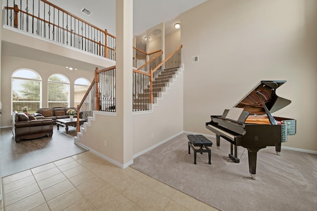 4010 Brookfield Run Ln, Sugar Land, TX 77479 - stairway with a high ceiling, baseboards, carpet floors, and tile patterned flooring