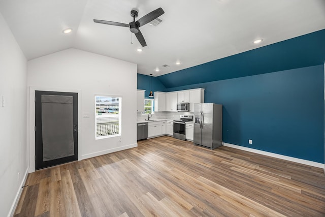 17070 Marie Village Dr, Conroe, TX 77306 - kitchen with appliances with stainless steel finishes, lofted ceiling, a sink, ceiling fan, and white cabinetry