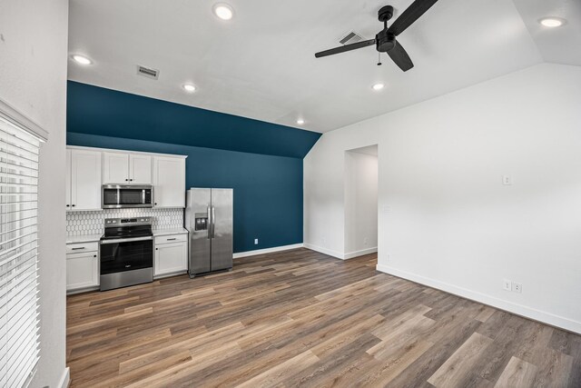 17070 Marie Village Dr, Conroe, TX 77306 - kitchen with stainless steel appliances, lofted ceiling, ceiling fan, white cabinetry, and wood finished floors