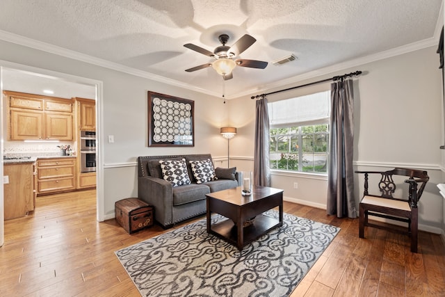 6509 Patricia St, Katy, TX 77493 - living area with a ceiling fan, a textured ceiling, light wood-style flooring, ornamental molding, and baseboards
