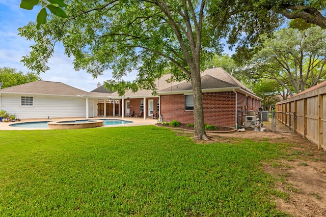 6509 Patricia St, Katy, TX 77493 - back of property featuring a pool with connected hot tub, brick siding, and a patio