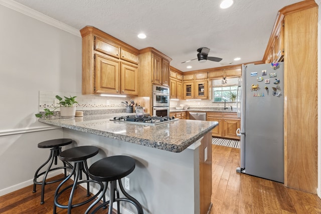 6509 Patricia St, Katy, TX 77493 - kitchen with stainless steel appliances, a peninsula, crown molding, ceiling fan, and a sink