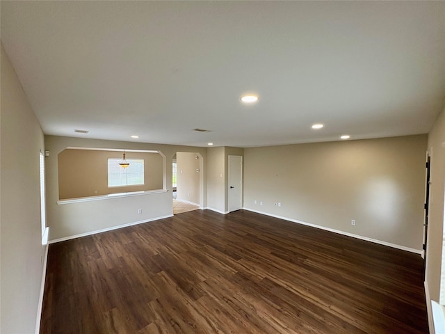 3403 Fox Ct, Pearland, TX 77581 - spare room featuring dark wood-type flooring, arched walkways, recessed lighting, and baseboards