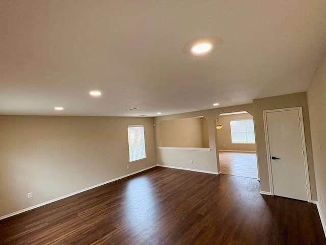3403 Fox Ct, Pearland, TX 77581 - empty room with arched walkways, baseboards, dark wood finished floors, and recessed lighting