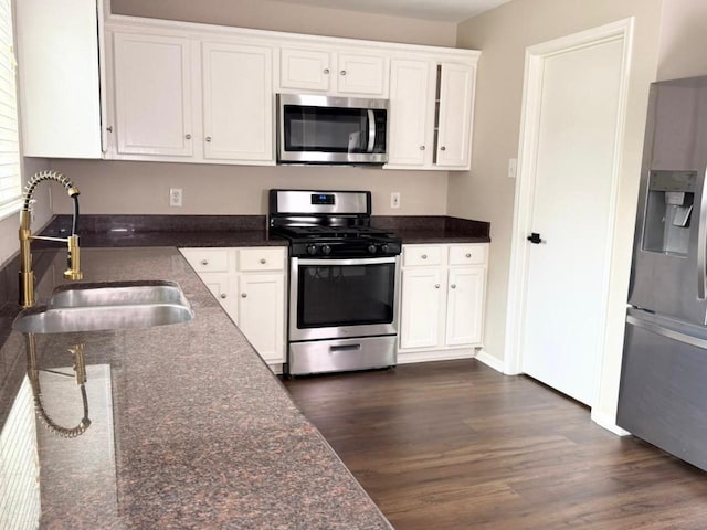3403 Fox Ct, Pearland, TX 77581 - kitchen featuring appliances with stainless steel finishes, a sink, dark wood-style floors, white cabinetry, and baseboards