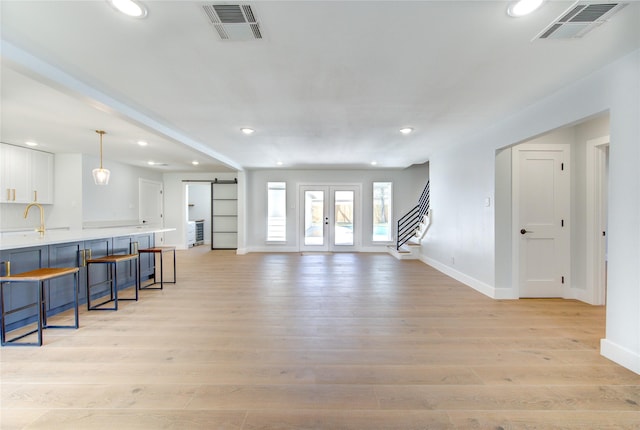 1810 Eagle Falls Ct, Houston, TX 77077 - unfurnished living room with recessed lighting, baseboards, stairs, a barn door, and light wood finished floors