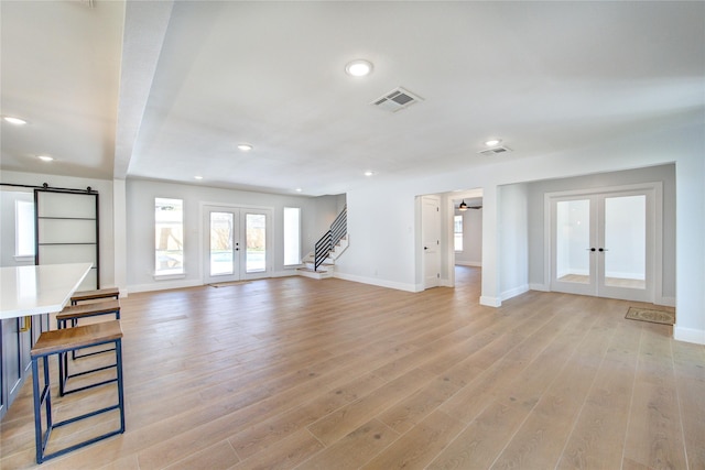 1810 Eagle Falls Ct, Houston, TX 77077 - unfurnished living room with french doors, a barn door, baseboards, recessed lighting, and light wood-style floors