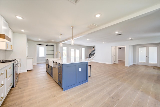 1810 Eagle Falls Ct, Houston, TX 77077 - kitchen featuring french doors, stainless steel appliances, a barn door, light countertops, and recessed lighting