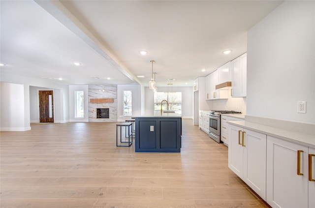 1810 Eagle Falls Ct, Houston, TX 77077 - kitchen with gas range, white cabinetry, open floor plan, a breakfast bar area, and light countertops