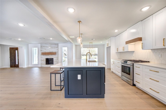 1810 Eagle Falls Ct, Houston, TX 77077 - kitchen with stainless steel range with gas stovetop, open floor plan, white cabinetry, light countertops, and recessed lighting