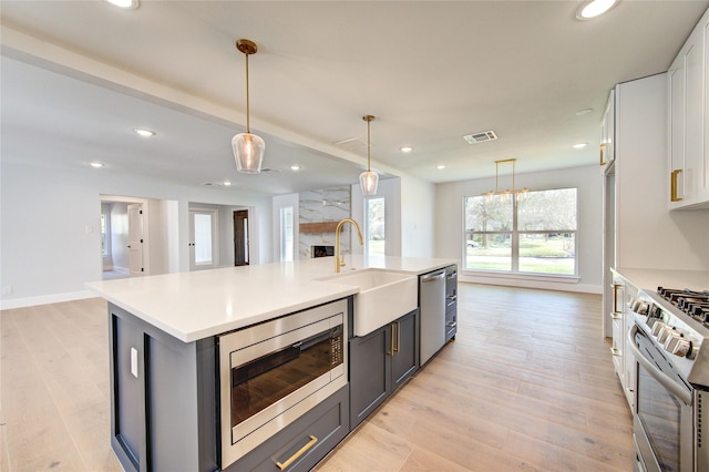 1810 Eagle Falls Ct, Houston, TX 77077 - kitchen featuring stainless steel appliances, a sink, light countertops, recessed lighting, and light wood-style flooring