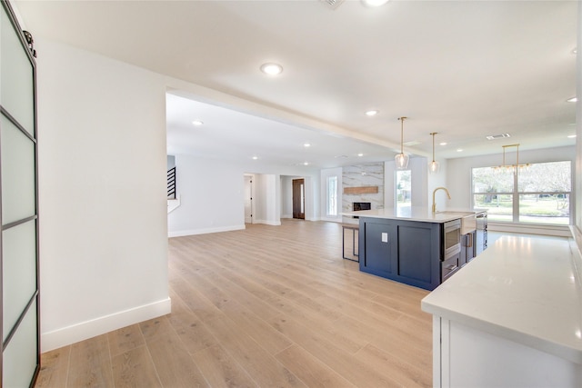 1810 Eagle Falls Ct, Houston, TX 77077 - kitchen featuring light countertops, recessed lighting, baseboards, open floor plan, and light wood-style flooring