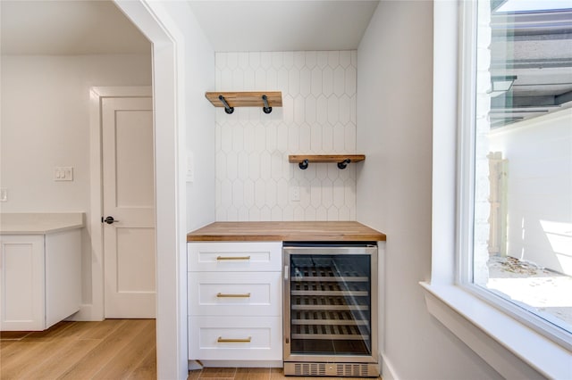 1810 Eagle Falls Ct, Houston, TX 77077 - bar with wine cooler, light wood finished floors, and decorative backsplash