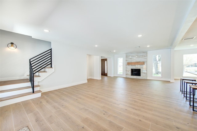 1810 Eagle Falls Ct, Houston, TX 77077 - unfurnished living room with light wood-style flooring, recessed lighting, baseboards, stairway, and a high end fireplace