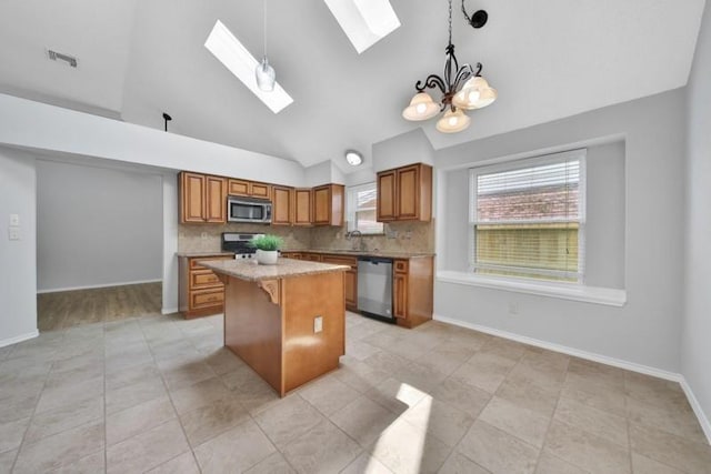 1223 Berrystone Trl, Missouri City, TX 77459 - kitchen featuring appliances with stainless steel finishes, a kitchen island, a skylight, brown cabinetry, and high vaulted ceiling