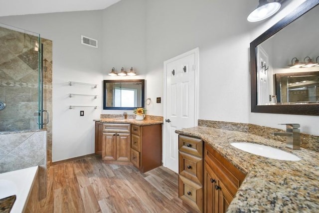 1223 Berrystone Trl, Missouri City, TX 77459 - full bathroom featuring a shower stall, wood finished floors, two vanities, a tub, and high vaulted ceiling