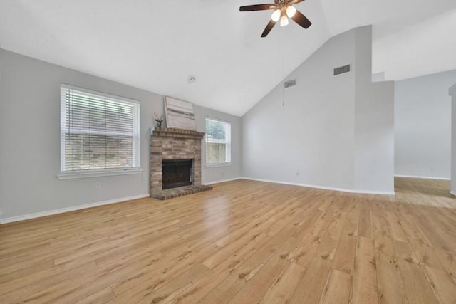 1223 Berrystone Trl, Missouri City, TX 77459 - unfurnished living room featuring light wood-style floors, ceiling fan, a brick fireplace, vaulted ceiling, and baseboards