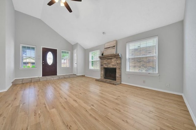 1223 Berrystone Trl, Missouri City, TX 77459 - unfurnished living room with a ceiling fan, light wood-style floors, a brick fireplace, lofted ceiling, and baseboards