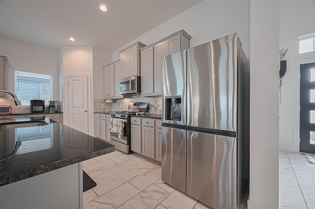 4507 Mustang Run Dr, Rosenberg, TX 77469 - kitchen featuring appliances with stainless steel finishes, light marble finish floors, gray cabinets, backsplash, and recessed lighting