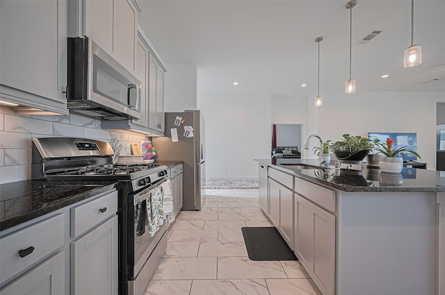 4507 Mustang Run Dr, Rosenberg, TX 77469 - kitchen featuring stainless steel appliances, a sink, light marble finish flooring, dark stone counters, and a center island with sink