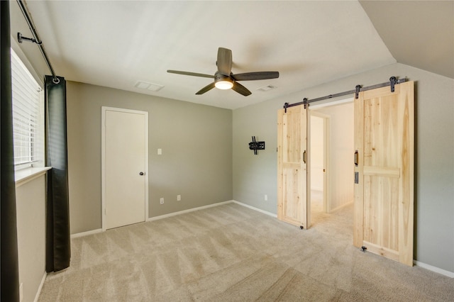 1802 Cobblestone Ct, Richmond, TX 77406 - unfurnished bedroom with a barn door, carpet, baseboards, and ceiling fan