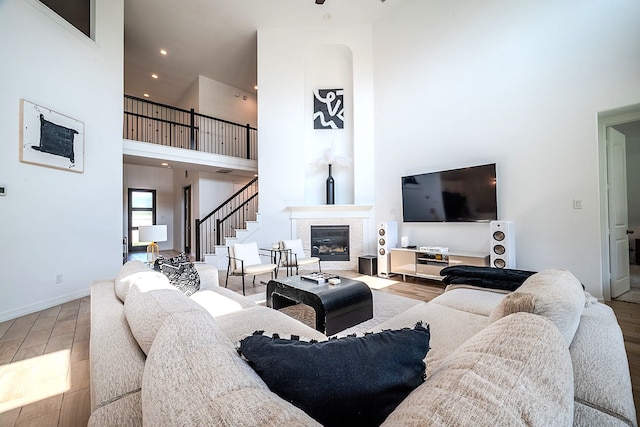 2003 Jitterbug Ln, Katy, TX 77493 - living area featuring a towering ceiling, wood finished floors, a tile fireplace, baseboards, and recessed lighting