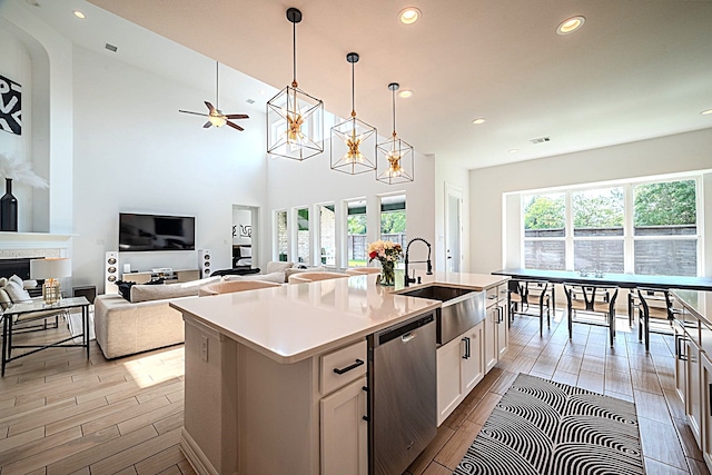 2003 Jitterbug Ln, Katy, TX 77493 - kitchen with stainless steel dishwasher, a sink, recessed lighting, wood finished floors, and white cabinetry